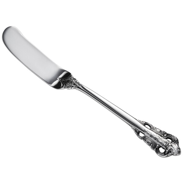 A silver butter spreader with a handle.
