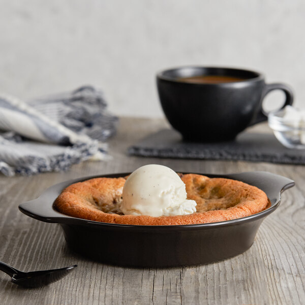 A black Acopa Caldera stoneware dish with food and ice cream on top.