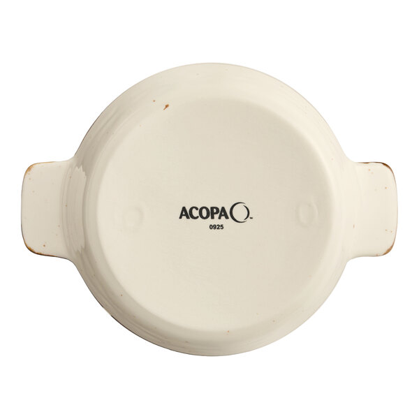 A small, round, vanilla bean-colored porcelain casserole dish with handles, viewed from the bottom and branded with the Acopa logo.