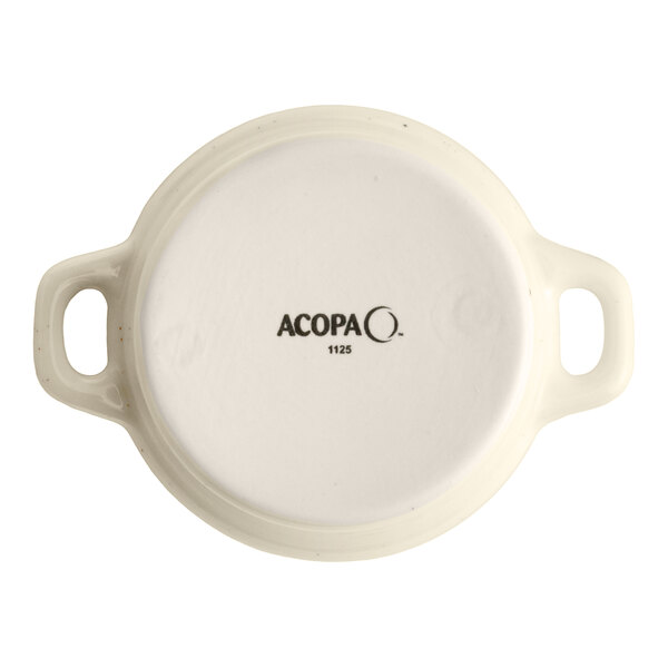 An Acopa Keystone 8 oz. vanilla bean stoneware mini casserole dish with handles, shown from the bottom.