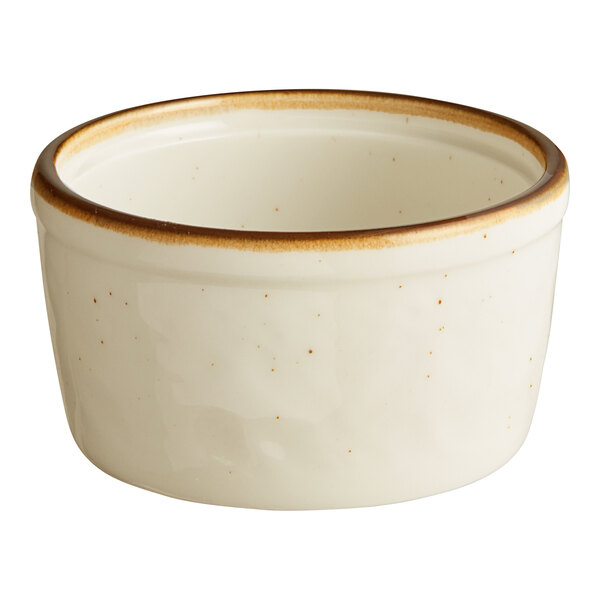 A small, round, vanilla-colored stoneware ramekin with a brown rim.