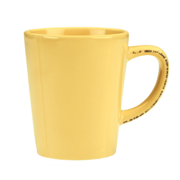 A Libbey butter yellow porcelain mug with a black handle.
