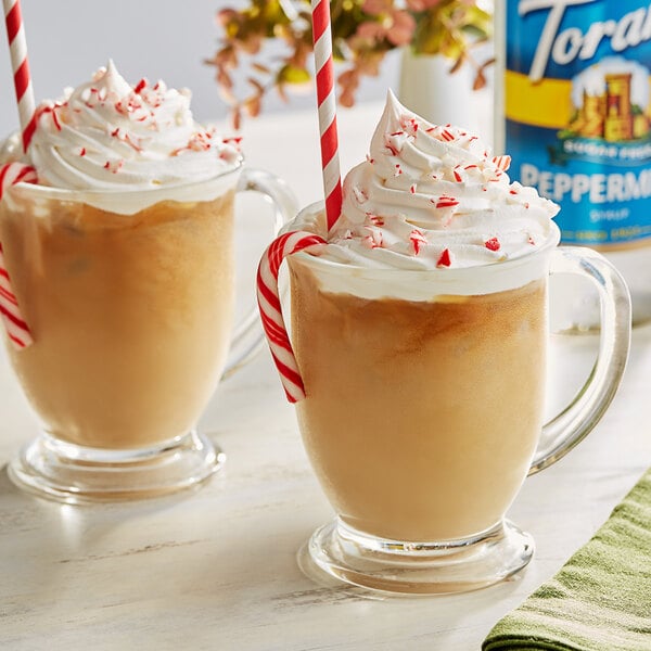 Two glasses of coffee with Torani Sugar-Free Peppermint syrup and candy canes.