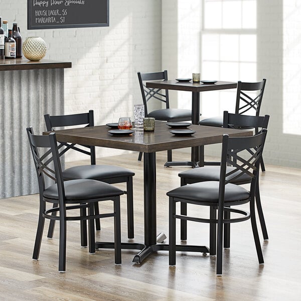 A Lancaster Table & Seating butcher block dining table with 4 chairs in a dining area.