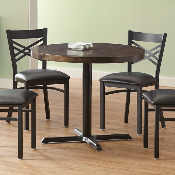A Lancaster Table & Seating round wood table with an espresso finish and cast iron base plate.