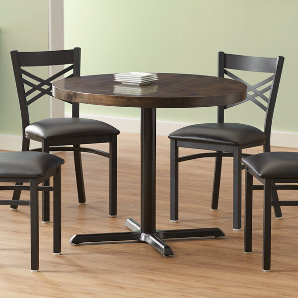 A Lancaster Table & Seating round wood table with an espresso finish and cast iron base plate.