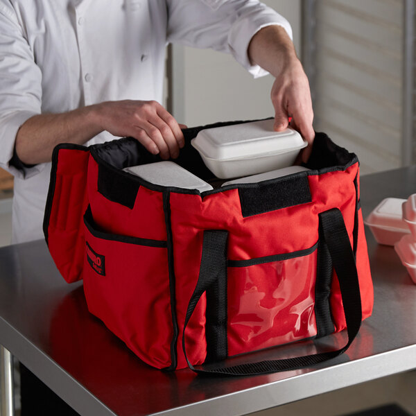 A man using a red Cambro Sandwich GoBag to hold food.