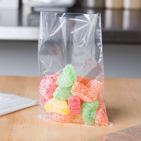 A LK Packaging plastic candy bag filled with pink and white gummy candies on a table.