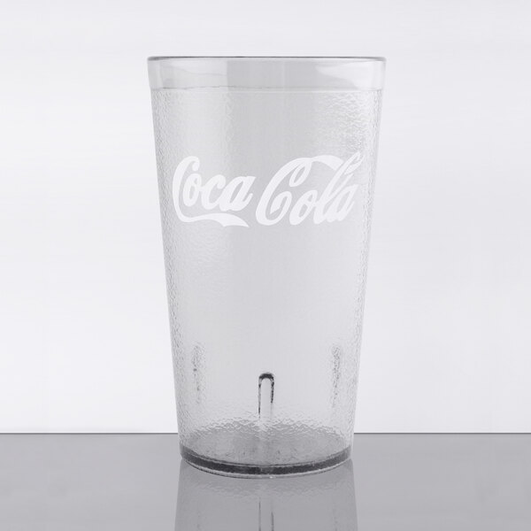 A clear plastic tumbler with a pebbled texture and a Coca Cola logo.