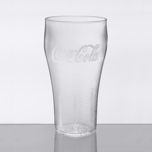 A clear plastic soda glass with a Coca-Cola logo.