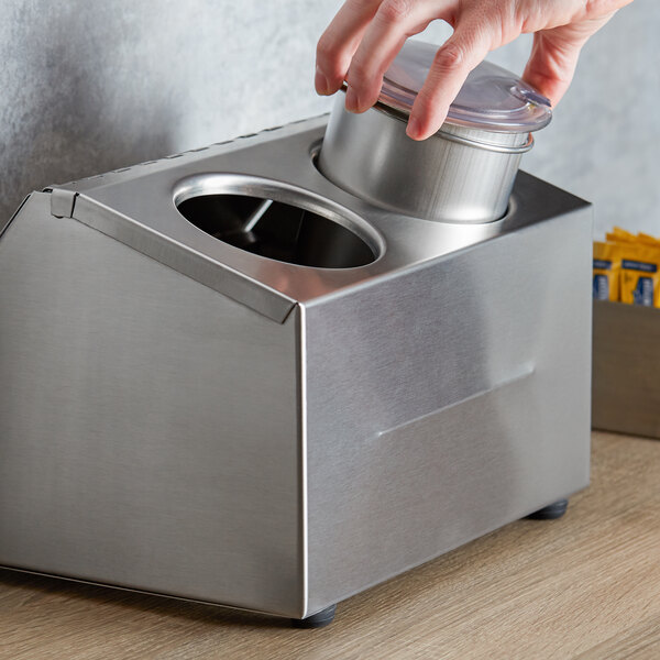 A hand picking up a Steril-Sil stainless steel container from an ice-cooled condiment dispenser.