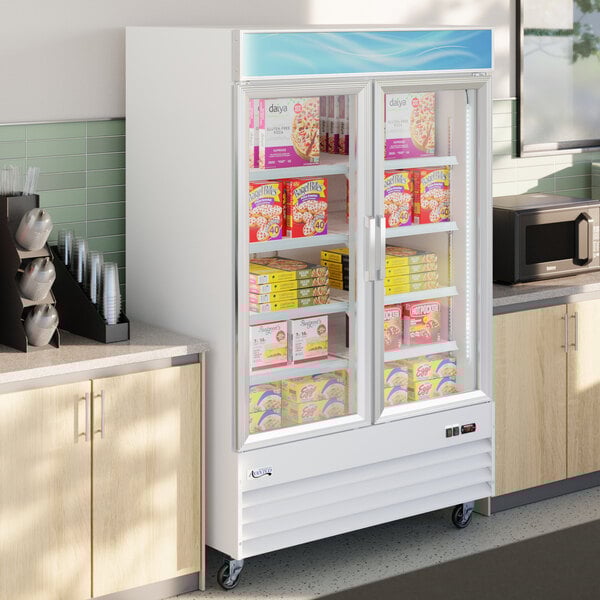 A white glass door merchandiser freezer with LED lighting, stocked with frozen food items.