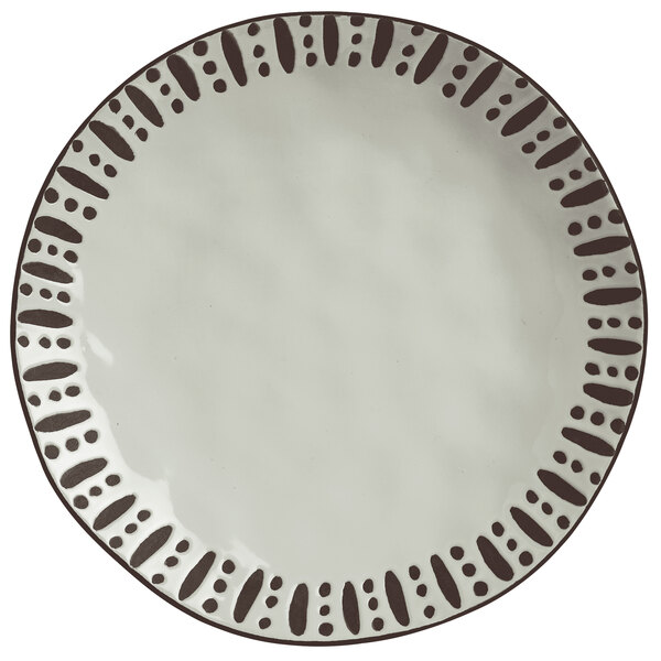 A white Libbey stoneware dinner plate with black dots on it.