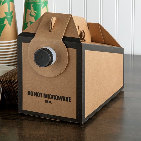 A brown and black Bagcraft Packaging box with a black JavaPac lid holding a paper coffee cup.