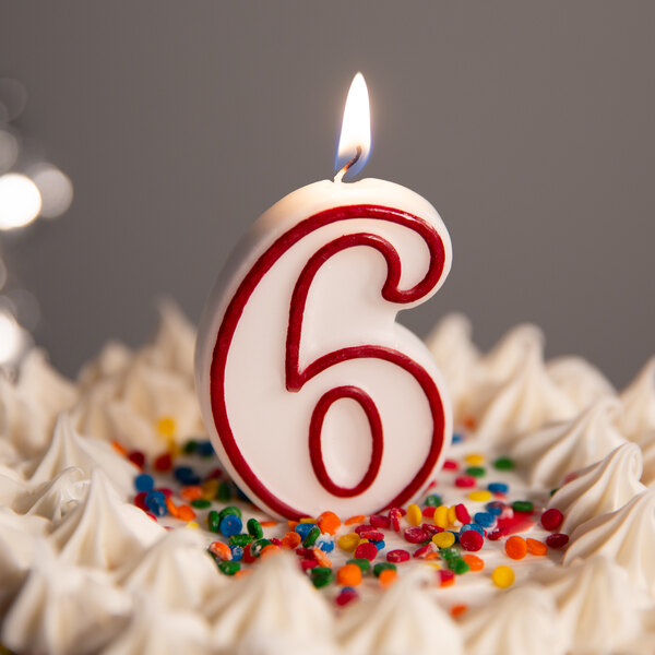 A white cake with a red outlined number six candle on top.