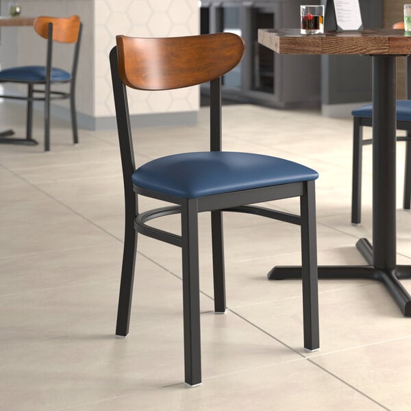 A Lancaster Table & Seating Boomerang chair with a navy seat at a restaurant table.
