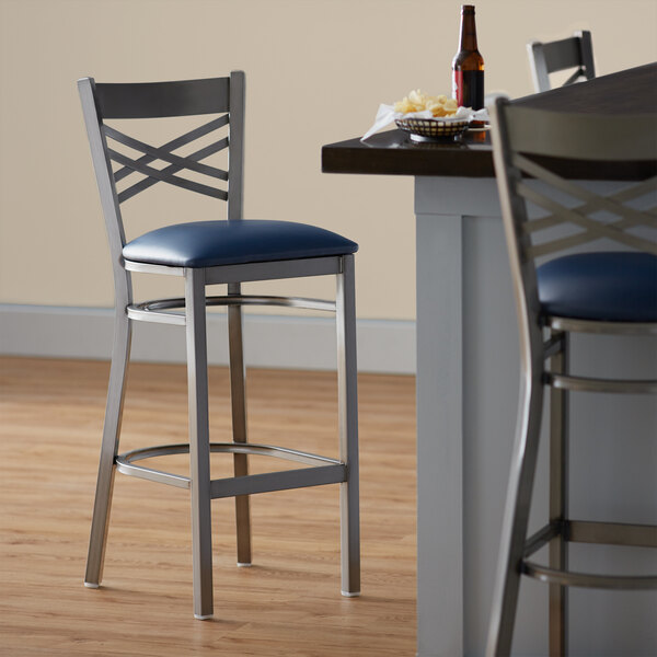 Lancaster Table & Seating Clear Coat Finish Cross Back Bar Stool with 2 1/2" Navy Vinyl Padded Seat