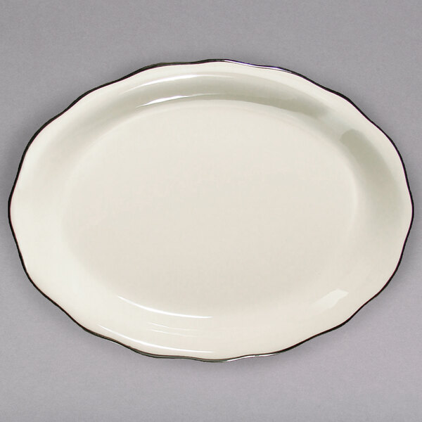A CAC ivory china platter with scalloped edges and a black band.