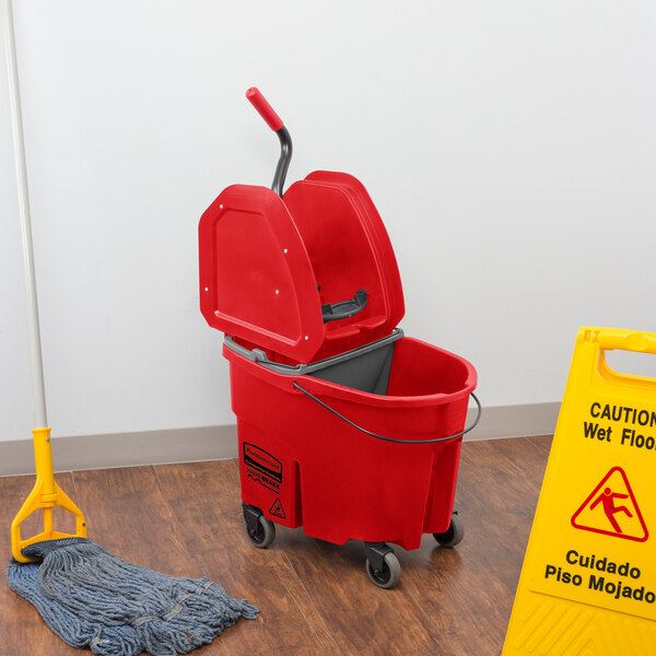 A Rubbermaid red mop bucket with a gray dirty water bucket and a handle.