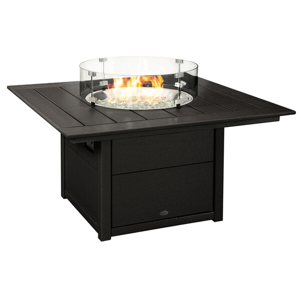A black POLYWOOD fire pit table with a glass top over a fire.