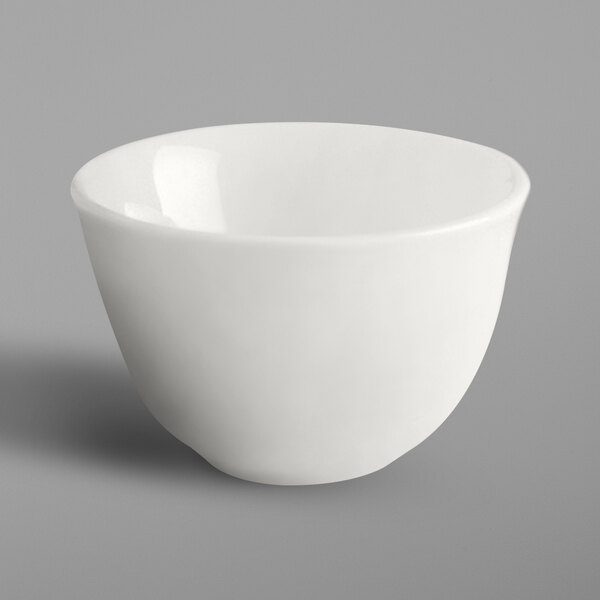 A RAK Porcelain ivory porcelain cup filled with a small amount of liquid on a white background.