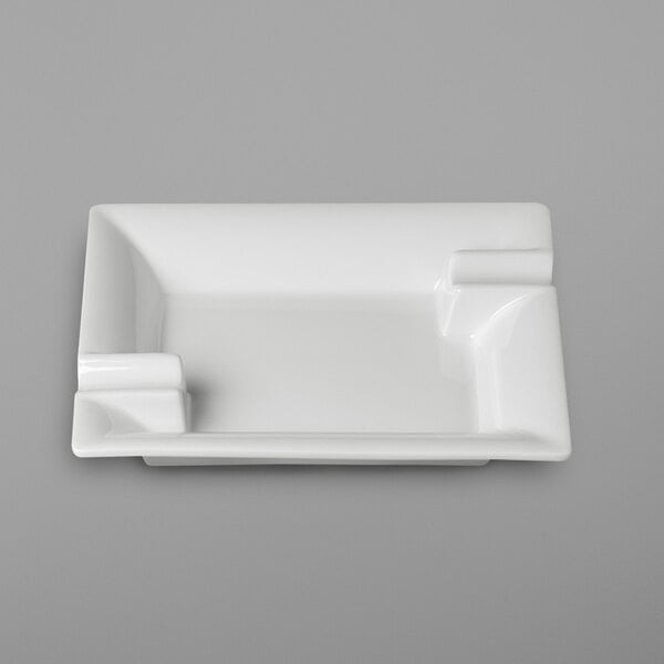 A white rectangular RAK Porcelain ashtray on a gray surface.