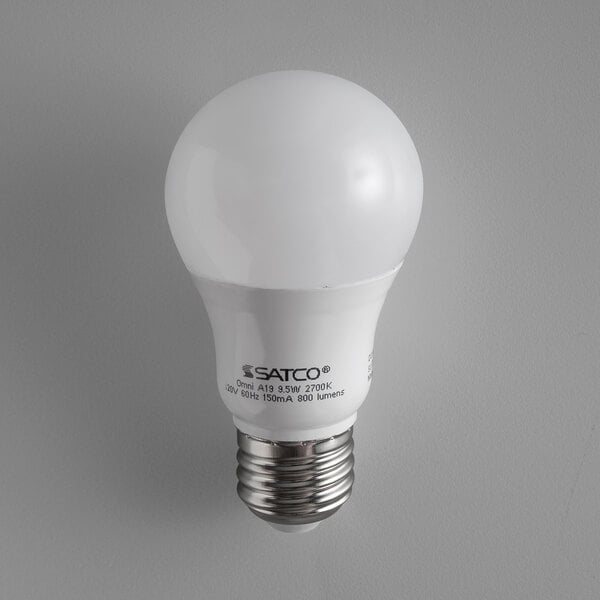 A frosted Satco LED light bulb with a white cap on a white background.