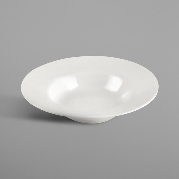 A white porcelain saucer with a light reflecting off of it.