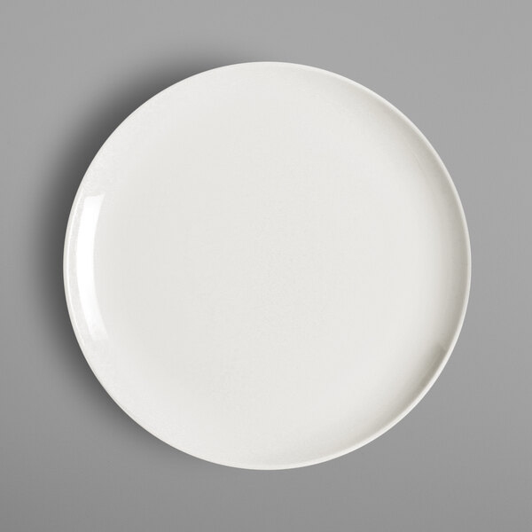 A white RAK Porcelain flat coupe plate on a gray background.