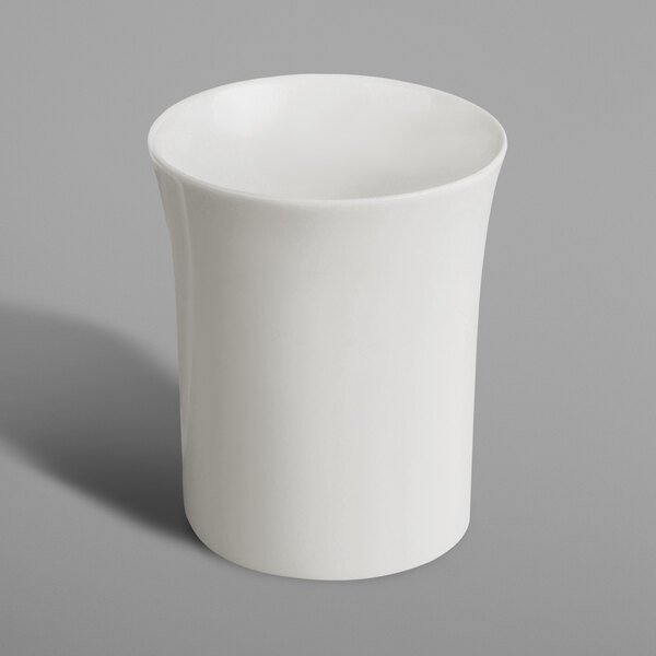 A white RAK Porcelain espresso cup with a handle on a gray surface.