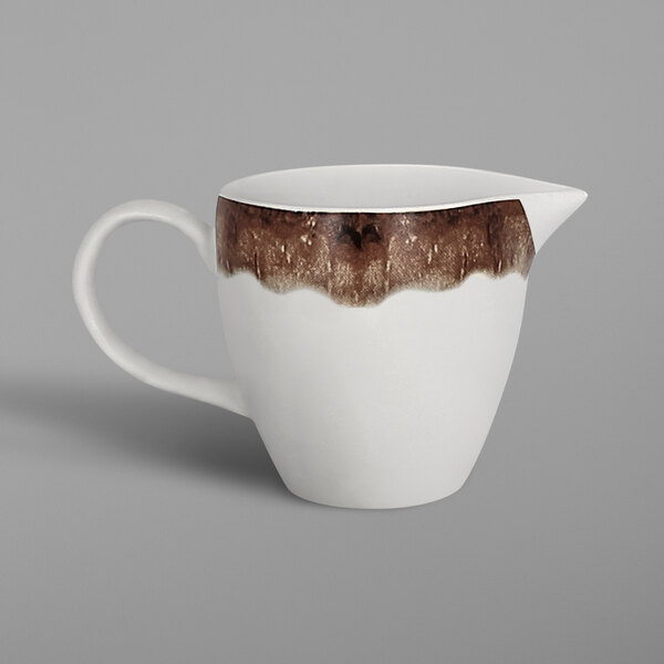 A white porcelain creamer with brown oak accents.