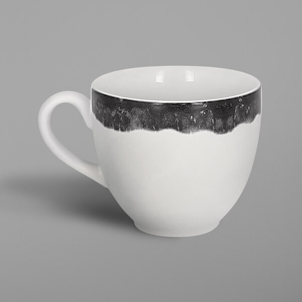A white porcelain coffee cup with a black and grey beech design.