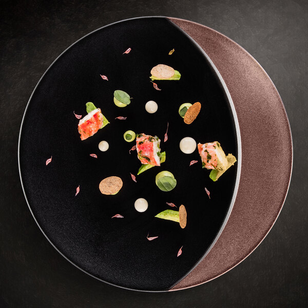 A RAK Porcelain bronze and black deep plate with food on it.