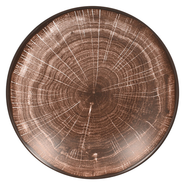 A brown RAK Porcelain Woodart deep coupe plate with a white circular pattern resembling tree rings.