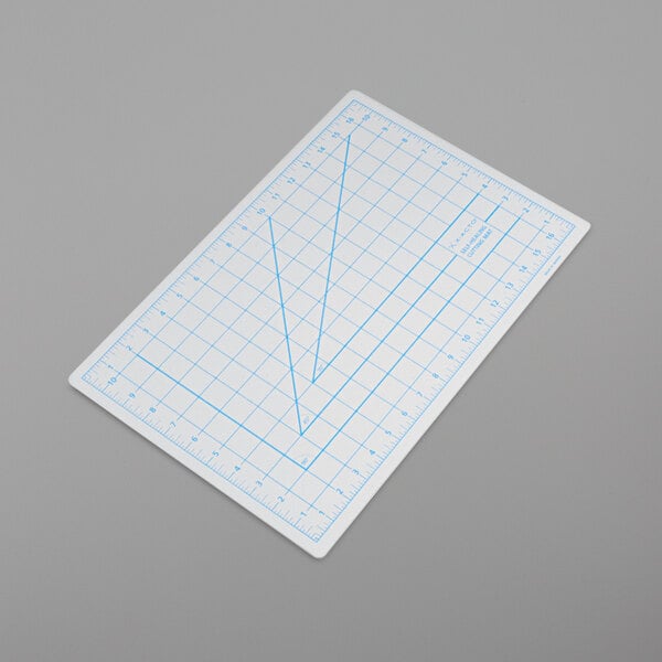 A white rectangular cutting mat with blue lines on it.