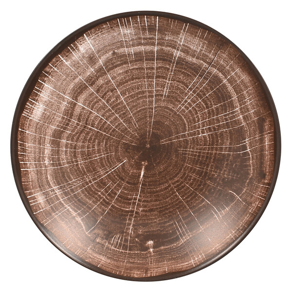 A brown RAK Porcelain Woodart deep coupe plate with a circular pattern resembling tree rings.