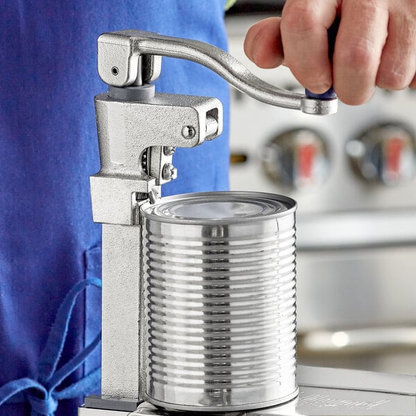 A person using an Edlund #2 Manual Can Opener to open a can.