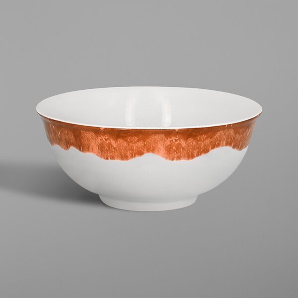 A white RAK Porcelain bowl with a brown and orange design on it.