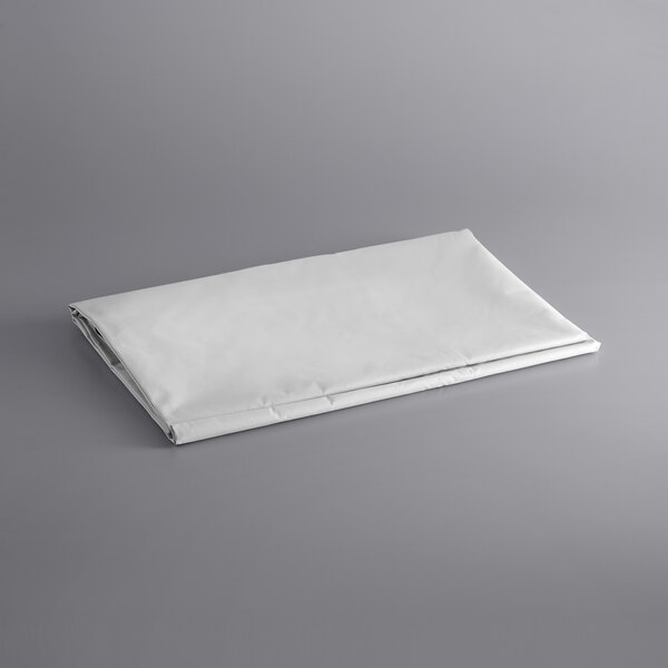 A folded white sheet on a gray surface.