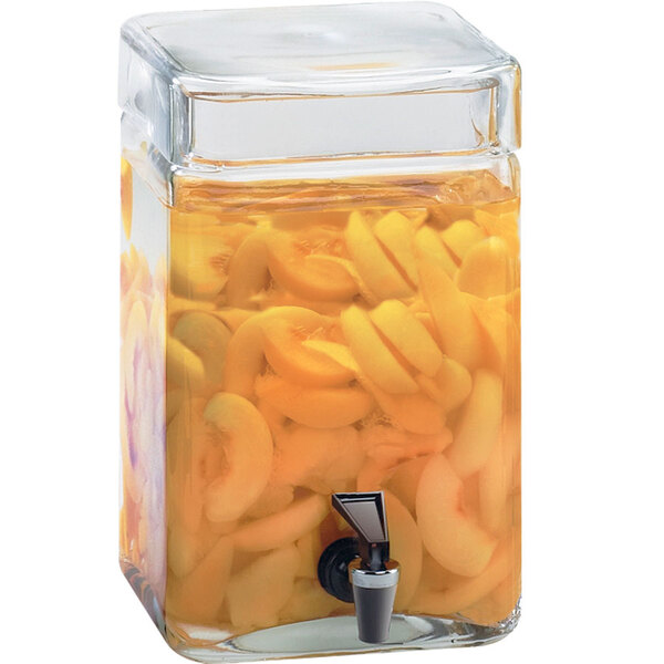 A Cal-Mil glass beverage dispenser filled with orange slices.