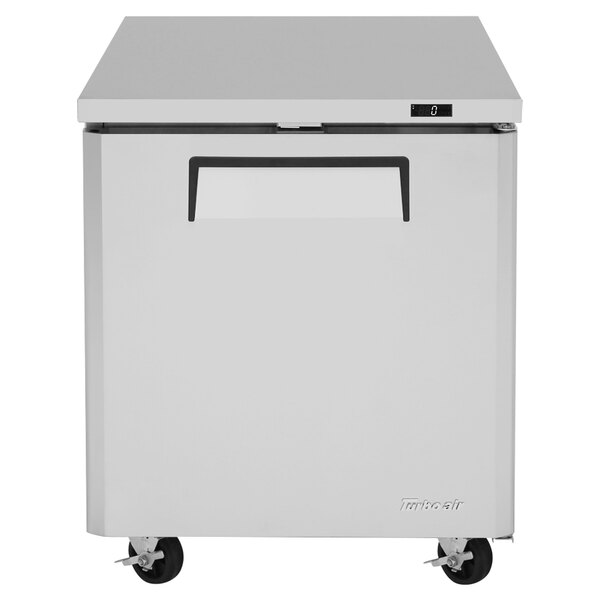 A stainless steel Turbo Air undercounter freezer with wheels.
