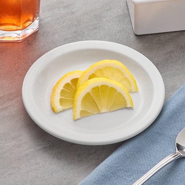 An Acopa bright white stoneware plate with lemon slices on it.