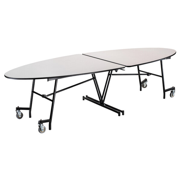 A white National Public Seating elliptical table with wheels on it.