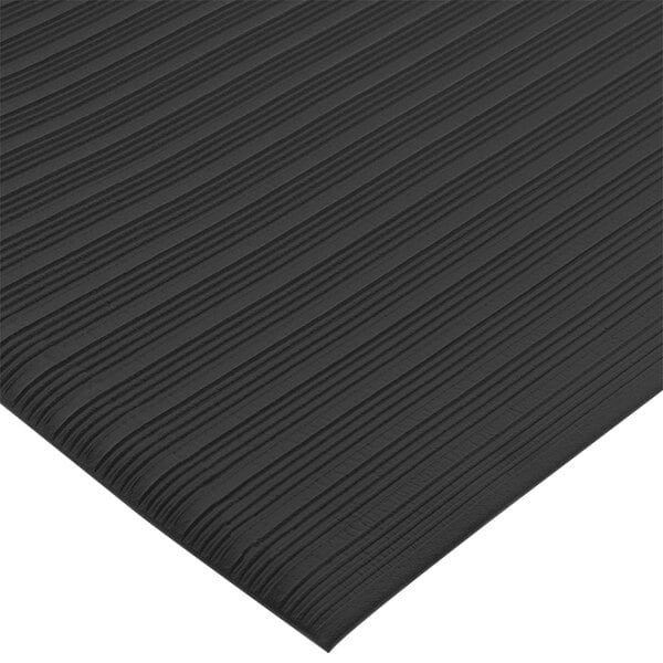 A close up of a black San Jamar anti-fatigue vinyl floor mat with a thin stripe pattern.
