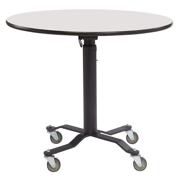 A National Public Seating round cafeteria table with black and white high pressure laminate top and wheels.