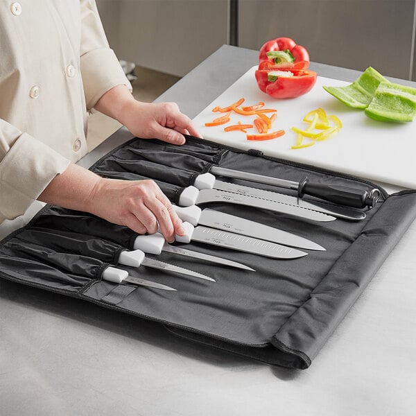 A woman using a Choice knife to cut vegetables on a cutting board.