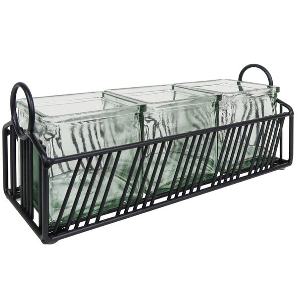 A black metal condiment organizer with three glass jars on a metal tray.