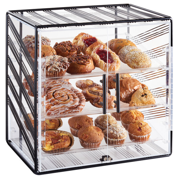 A Cal-Mil black bakery display case filled with muffins, doughnuts, and pastries.