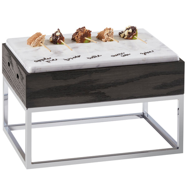 A Cal-Mil Cinderwood marble and metal riser on a table with food.