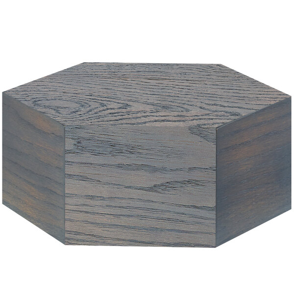 A hexagon shaped oak wood riser with a gray finish.